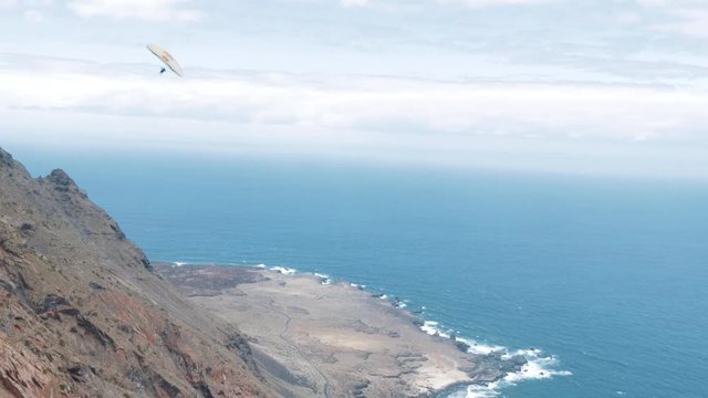 Freestyle acro paragliding along the cliff