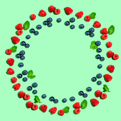 Blueberries and raspberries on a solid color background