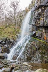 Blurred long exposure photograph of Boyanski waterfall, the Boyana river near Sofia, Bulgaria in fall, cold autumn day