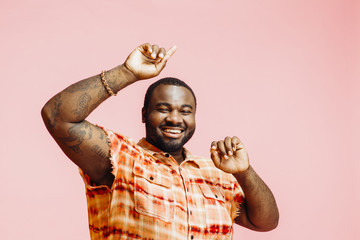 Happy plus size man with arms up, feeling great and smiling at camera
