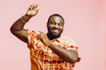 Happy plus size man with arms up, feeling great and smiling at camera