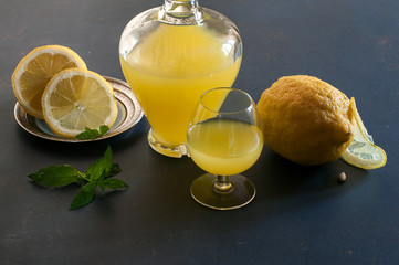 Bottiglia di limoncello e limoni di Sorrento decorati con la menta