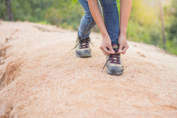 woman tying shoe laces, Closeup of female tourist getting ready for hiking, Hiking shoes .