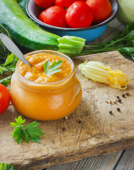 Squash zucchini paste in a glass jar surrounded by the ingredients