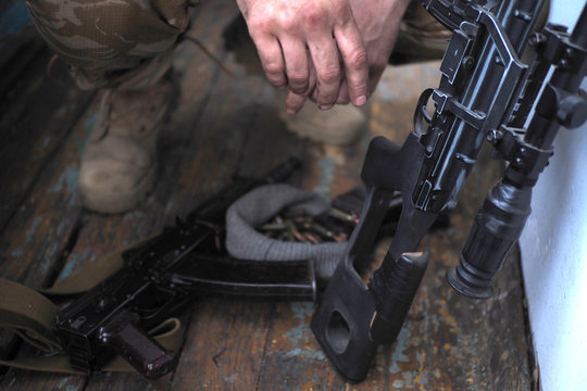 soldier hands and AK rifle on the floor. Sniper rifle
