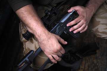 soldier hands and Sniper rifle close up. war.