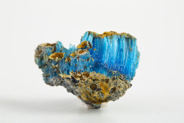Blue mineral chalcanthite (copper sulfate) on stone on a white background