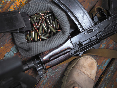 soldier feet and AK rifle on the floor close up.