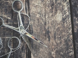 Obraz premium Hair cutting shears on wood background
