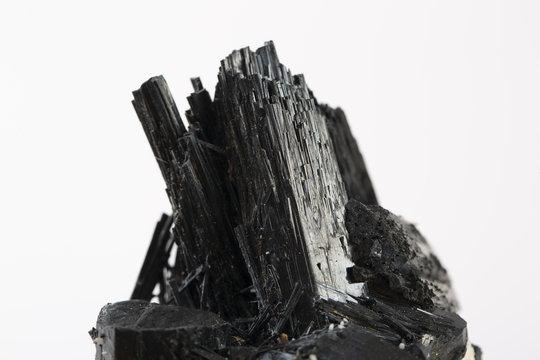 Extreme close up of black tourmaline mineral isolated over white background in focus stacking technique