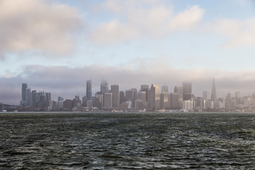 Naklejka premium Widok na centrum San Francisco i dzielnicę finansową z wyspy Treasure z późną popołudniową mgłą w Kalifornii, USA