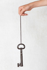 Key in hand hanging on a string 
