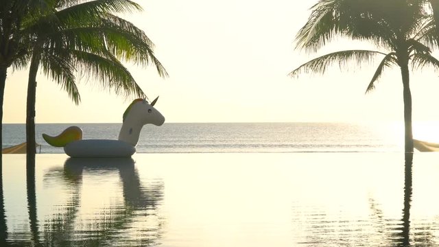 Pool by the beach in the morning with floating unicorn