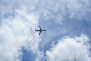 Fototapeta na wymiar Airplane flying in the cloudy sky