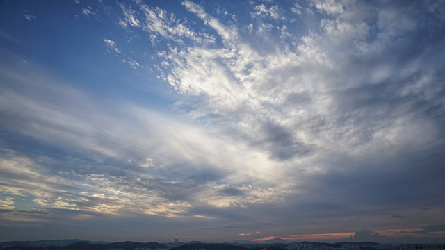 Sky and clouds at sunset over silhouettes buildings
