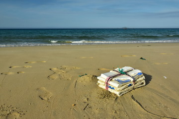 Self-made white polystyrene buoy a tied to a rope network fishing fish on a wet sand background ocean design beach fishing village. Garbage thrown ashore by waves