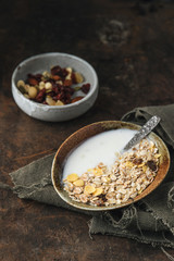 Healthy breakfast. Fresh granola, muesli with yogurt, nuts and dried berries on rustic background. 