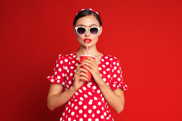Obraz premium cheerful brunette pin-up girl holding soft drink