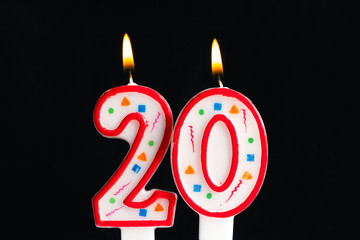 Colorful burning birthday candle  on dark background