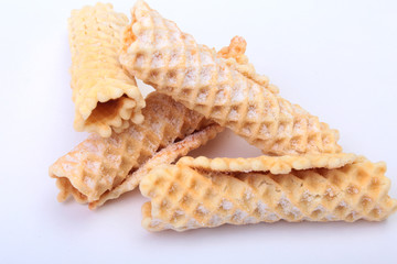 Homemade wafer rolls with powdered sugar isolated on white background