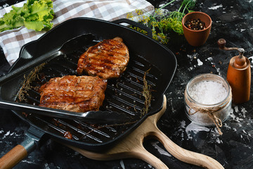 grilled beef fillet steaks with herbs and spices on dark background. Food concept