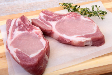 Raw pork chops, spices and rosemary on cutting board. Ready for cooking.