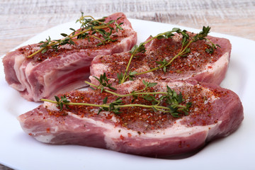 Raw pork chops, spices and rosemary on cutting board. Ready for cooking.