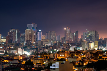 Fototapeta na wymiar Manila skyline at night with high rise buildings and ordinary residential housing
