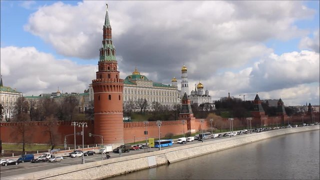 Russia, Moscow, center - view from the Big stone bridge on the Kremlin wall, the Church with Golden domes, towers of red square, traffic on the Kremlin quay in the spring against the cloudy sky