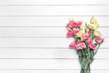 Beautiful pink eustoma flowers on white wooden background. Copy space, top view,