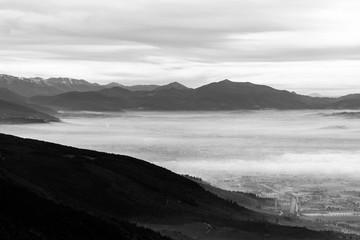 Beautiful aerial view of Umbria valley in a winter morning, with fog covering trees, houses and streets