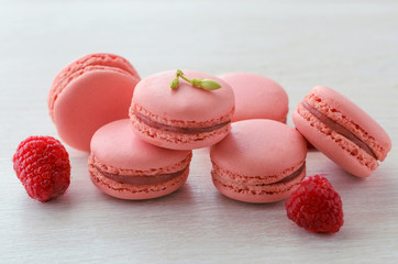 Pink raspberry macarons on wooden table. French dessert macaroons on white  background.
