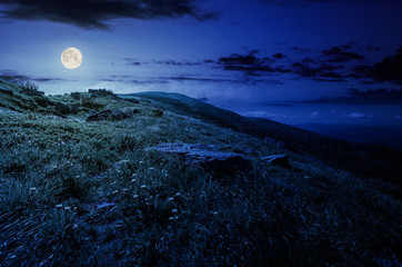 rocks on grassy hillside of the mountain at night