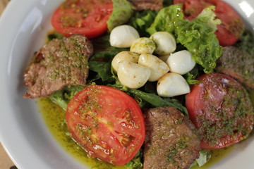 beef and tomatoes salad with mozzarella cheese and pesto sauce 