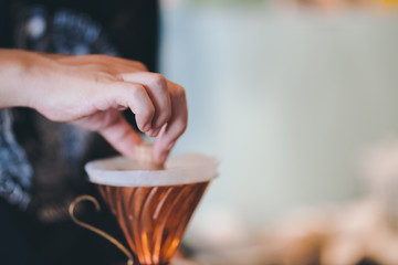 barista prepare ground coffee in dripper to brew coffee