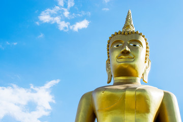 Fototapeta premium Big golden Buddha statue with blue sky background.
