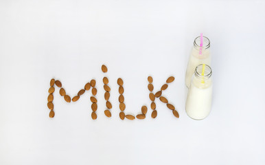 Almond milk in small bottles and almonds