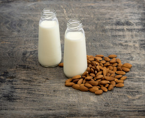 Almond milk in small bottles and almonds