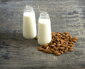 Almond milk in small bottles and almonds