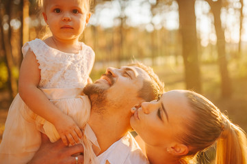 Young family on vacation, having great time together smiling while walking in the park. Father...
