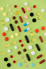 top view of arranged various pills on green background