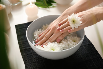 Young woman undergoing spa manicure treatment in beauty salon