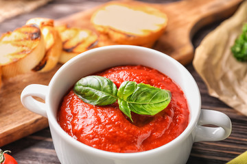 Tureen with tasty tomato sauce on table, closeup