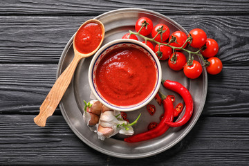 Composition with tasty tomato sauce on wooden background