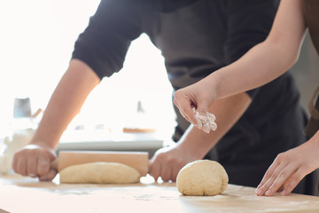 Bakers preparing dough on kitchen table