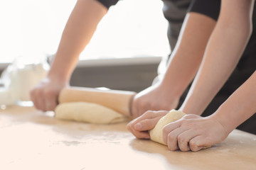Obraz na płótnie Canvas Bakers preparing dough on kitchen table
