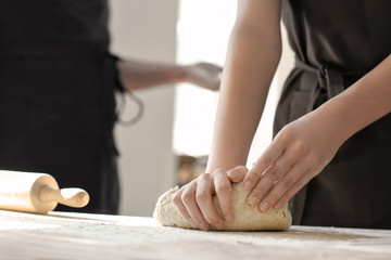 Fototapeta na wymiar Baker kneading dough on kitchen table