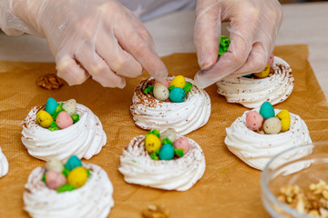 Obraz na płótnie Canvas Mini Pavlova meringue nest with eggs, easter sweets, cooking process