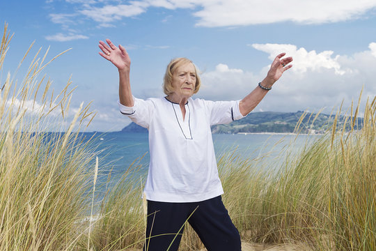 An old woman practicing Tai chi - Powered by Adobe