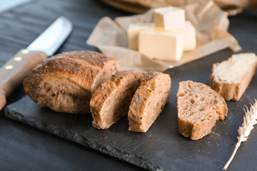 Slate plate with freshly baked bread on table